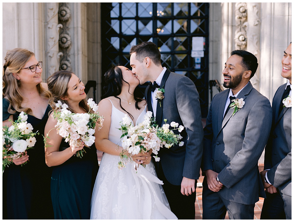 Small Wedding Trend: Minimony bride and groom kissing after ceremony with small group of friends, San Francisco bay area
