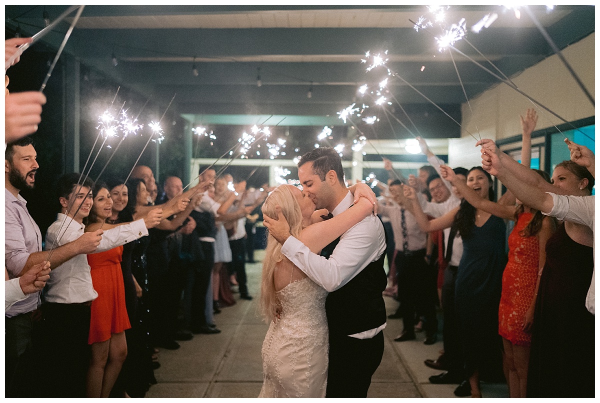 kissing under wedding sparklers