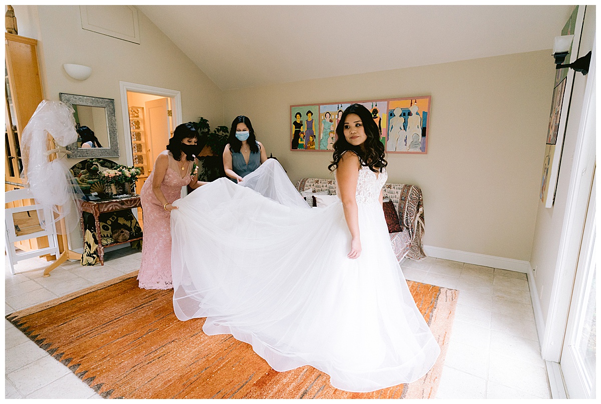 Brianna putting on her wedding dress before the Half Moon Bay Elopement ceremony