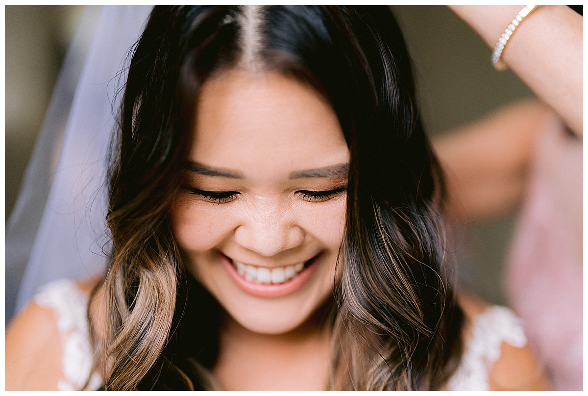 Brianna laughing as she gets help with her bridal veil