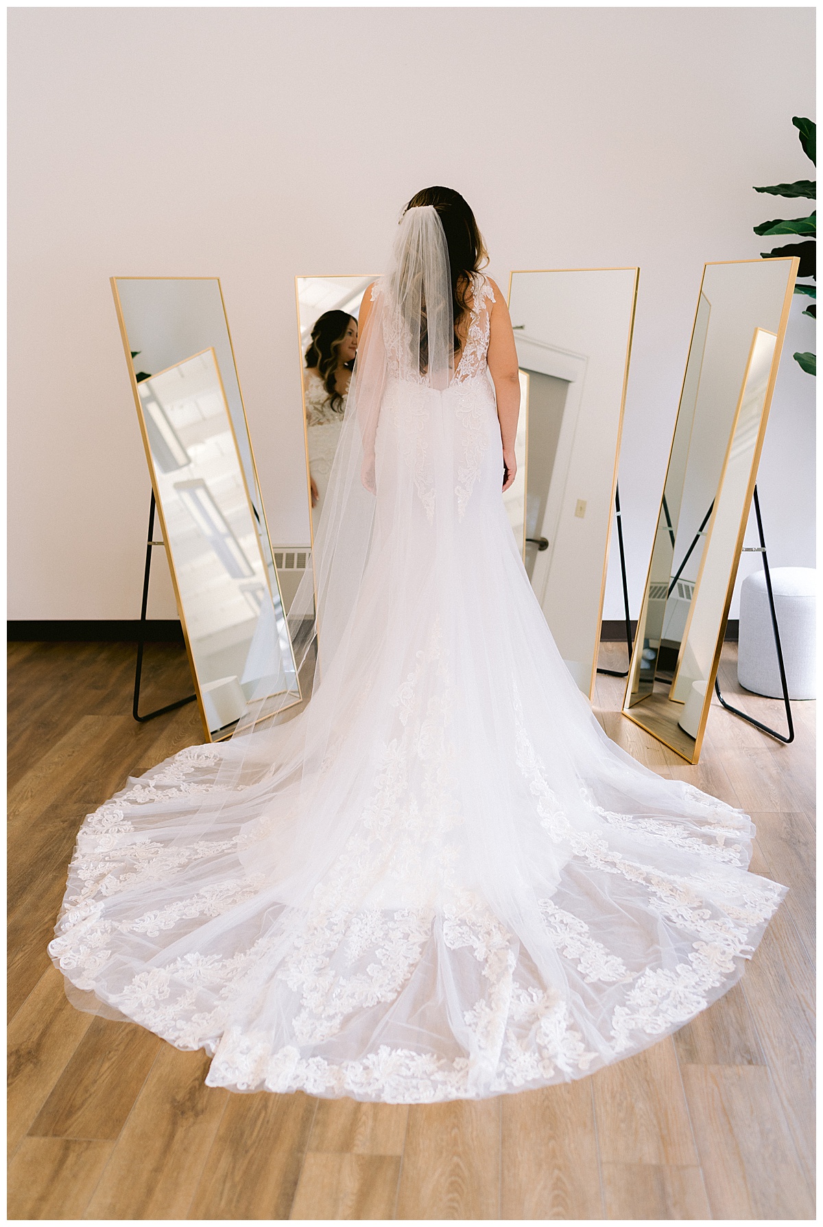 Keyla looking in mirrors, with long veil and train spread out