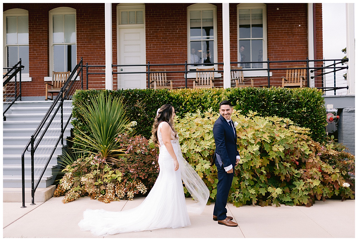 Renato looks over his shoulder at Keyla for their first look before the Golden Gate Club Wedding 