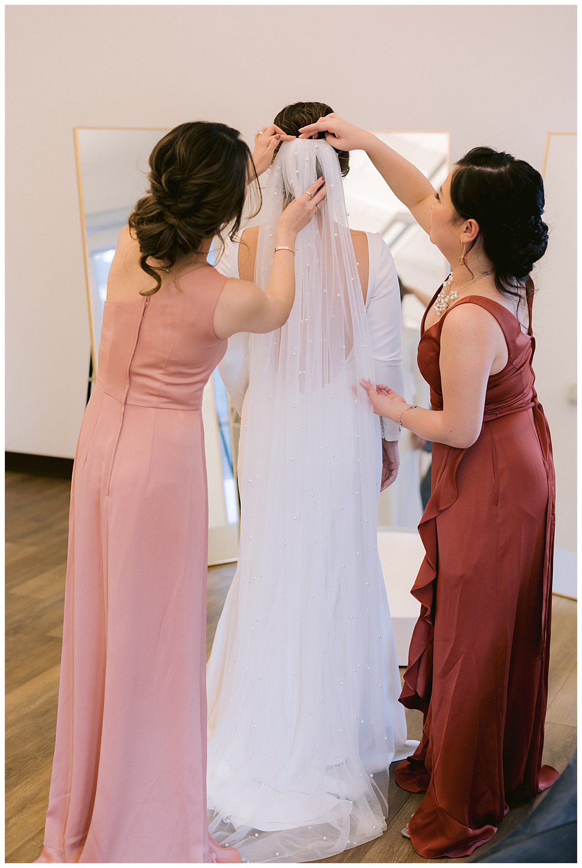 Vivian getting help putting on her long, pearl studded bridal veil