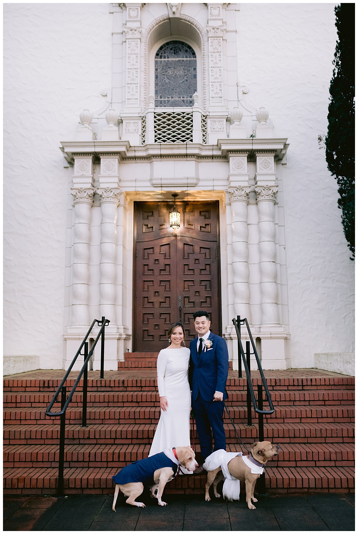 Vivian and Edward with their dressed up dogs in front of the Presidio Chapel