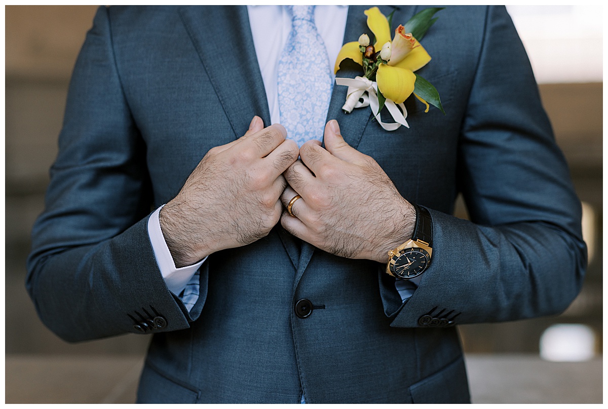 Detail shot of Ashir's watch, ring, and boutonniere 