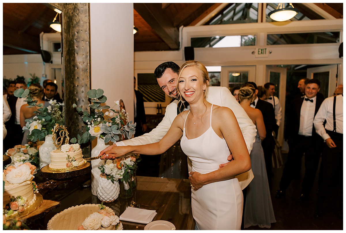 bride and groom cutting the cake at during their reception