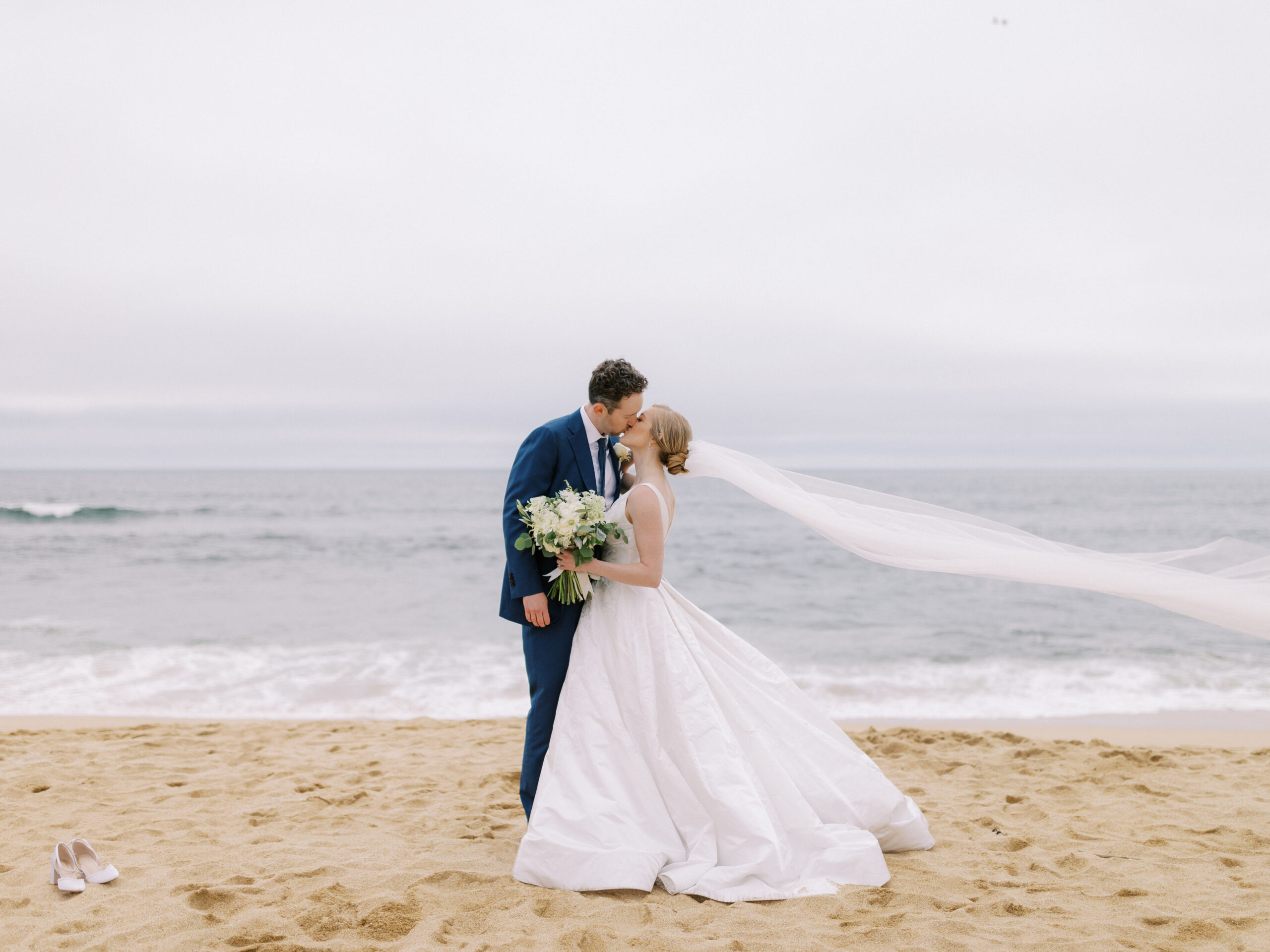 Bride and groom kissing on the beach