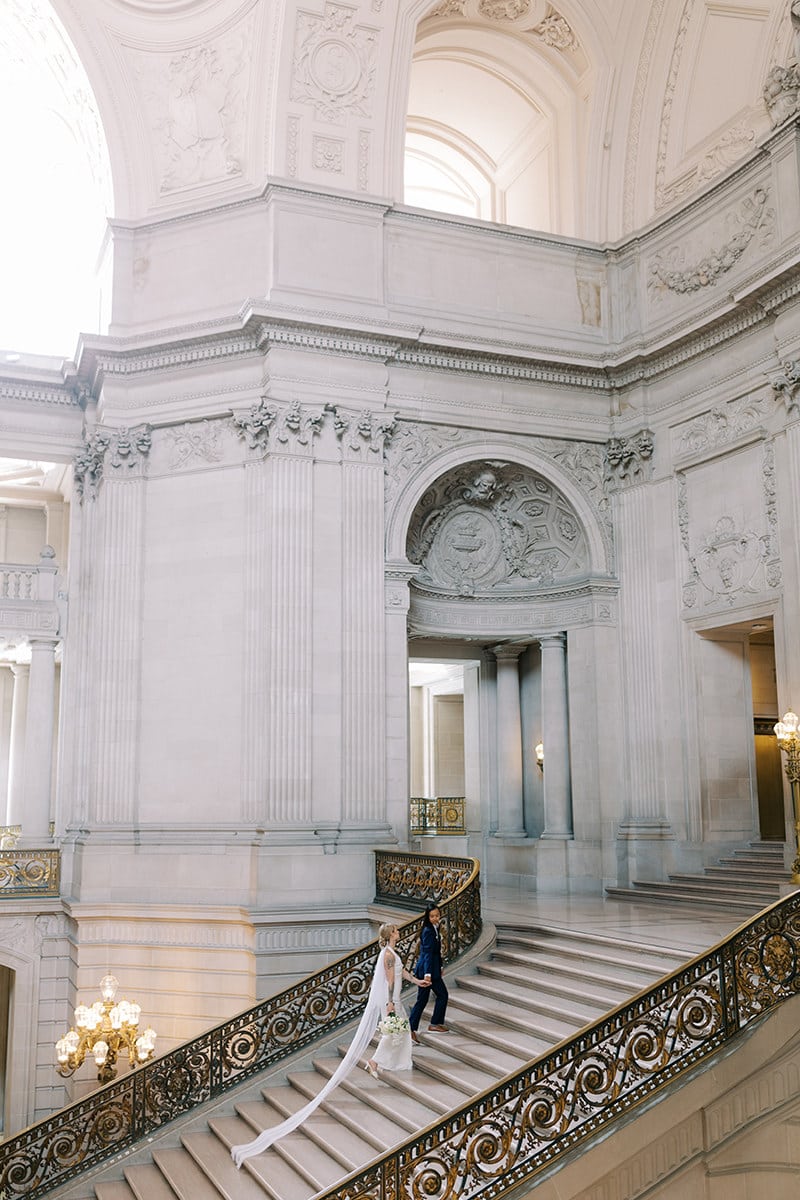 lesbian couple walking up the grand staircase at San Francisco city hall