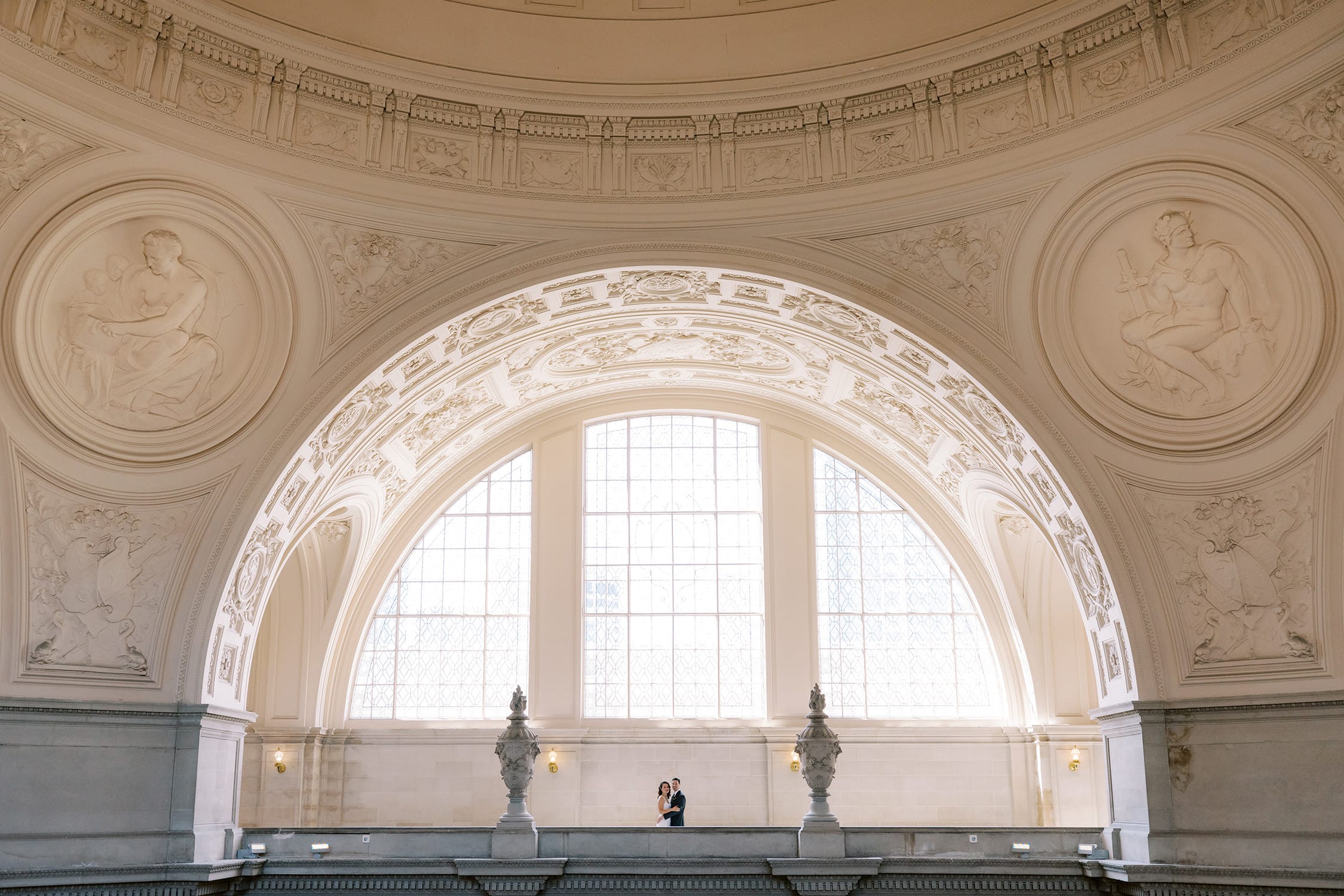 wide photo of couple posing together across sf city hall