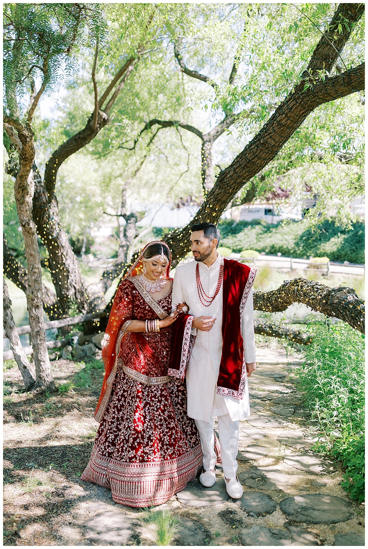 indian couple walking amongst trees at Nella Terra