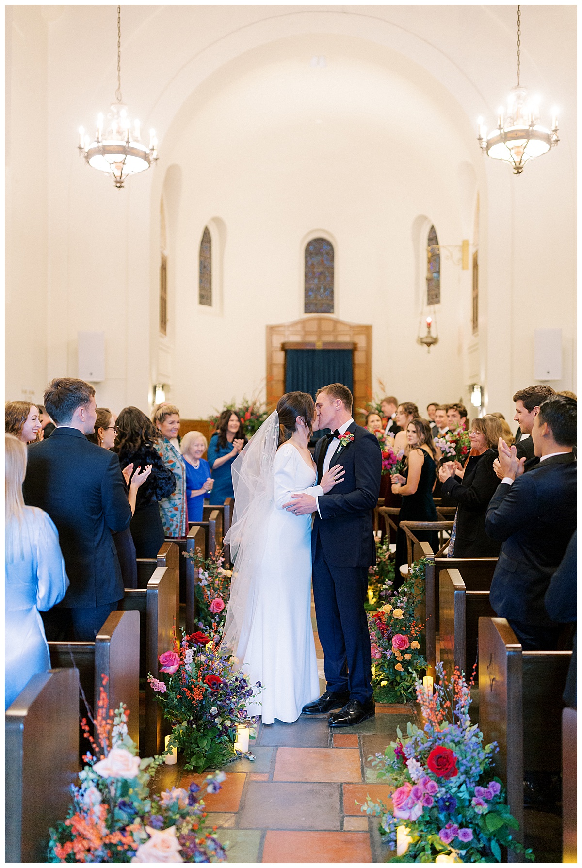 Bride and groom kissing as they walk back up the aisle after their ceremony