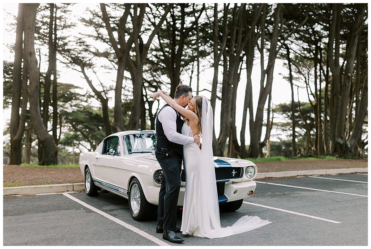 couple kissing in front of vintage car at lands end in San Francisco