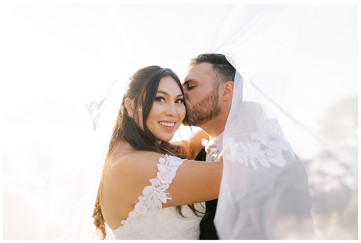 couple kissing under the veil at sunset at carmel highlands Hyatt 