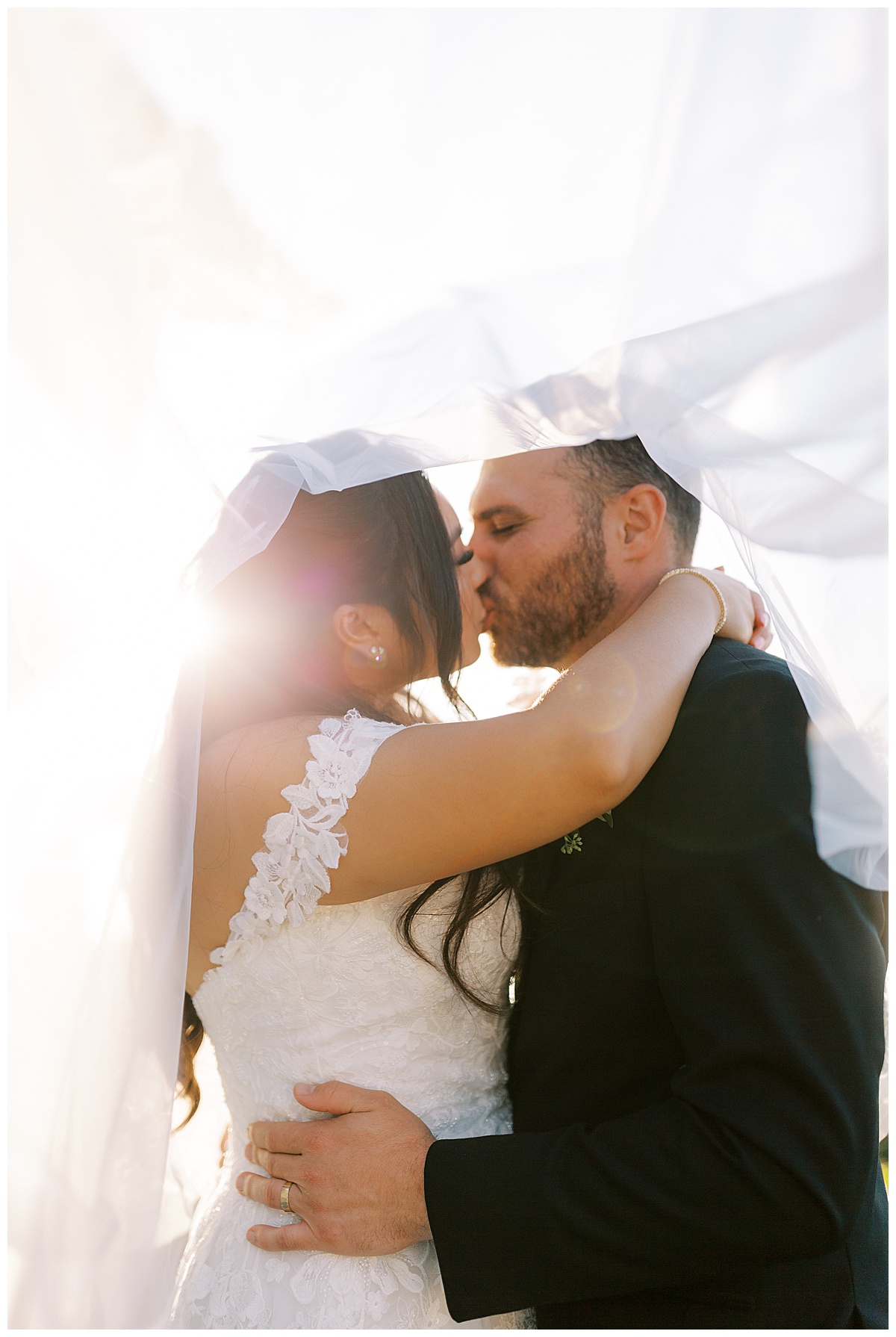 couple kissing under the veil at carmel highlands Hyatt at sunset