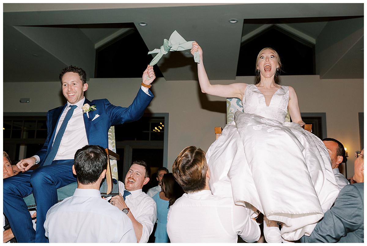 couple lifted in the air on chairs during their wedding reception at Oceano Hotel