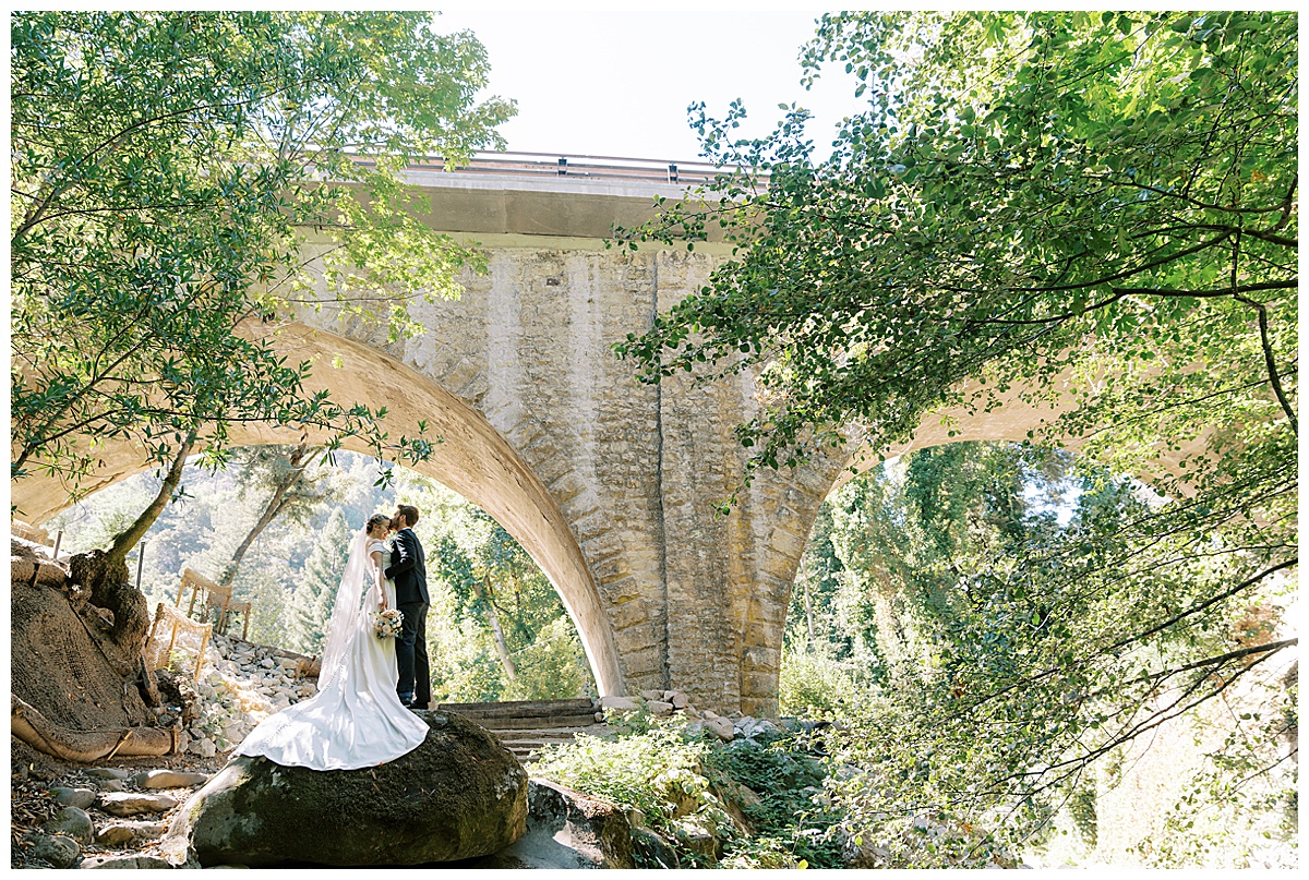 wide couples portrait of couple standing on a rock at saratoga springs