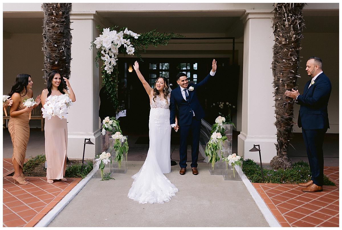 couple waving to guests after wedding ceremony at golden gate club