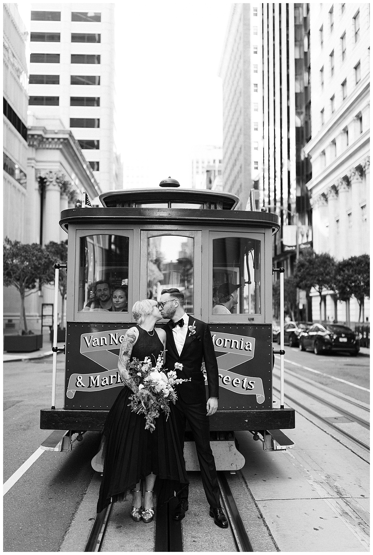 black and white photo of couple kissing in front of cable car in San Francisco 