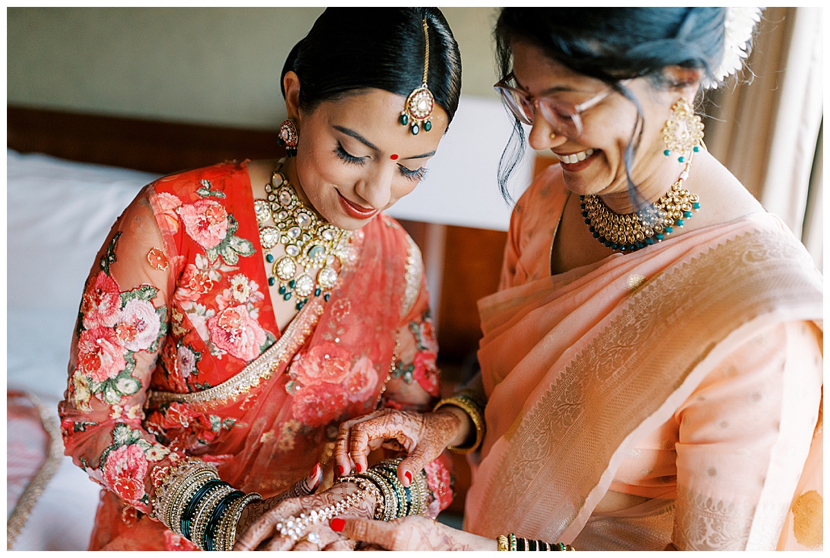 mother helping bride put on bangles at Westin sfo before wedding
