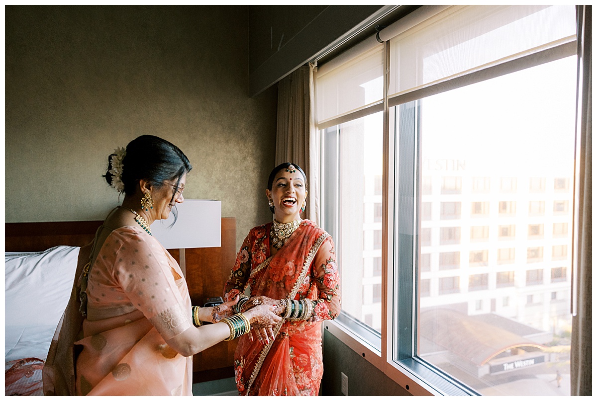 bride laughing with mother before wedding