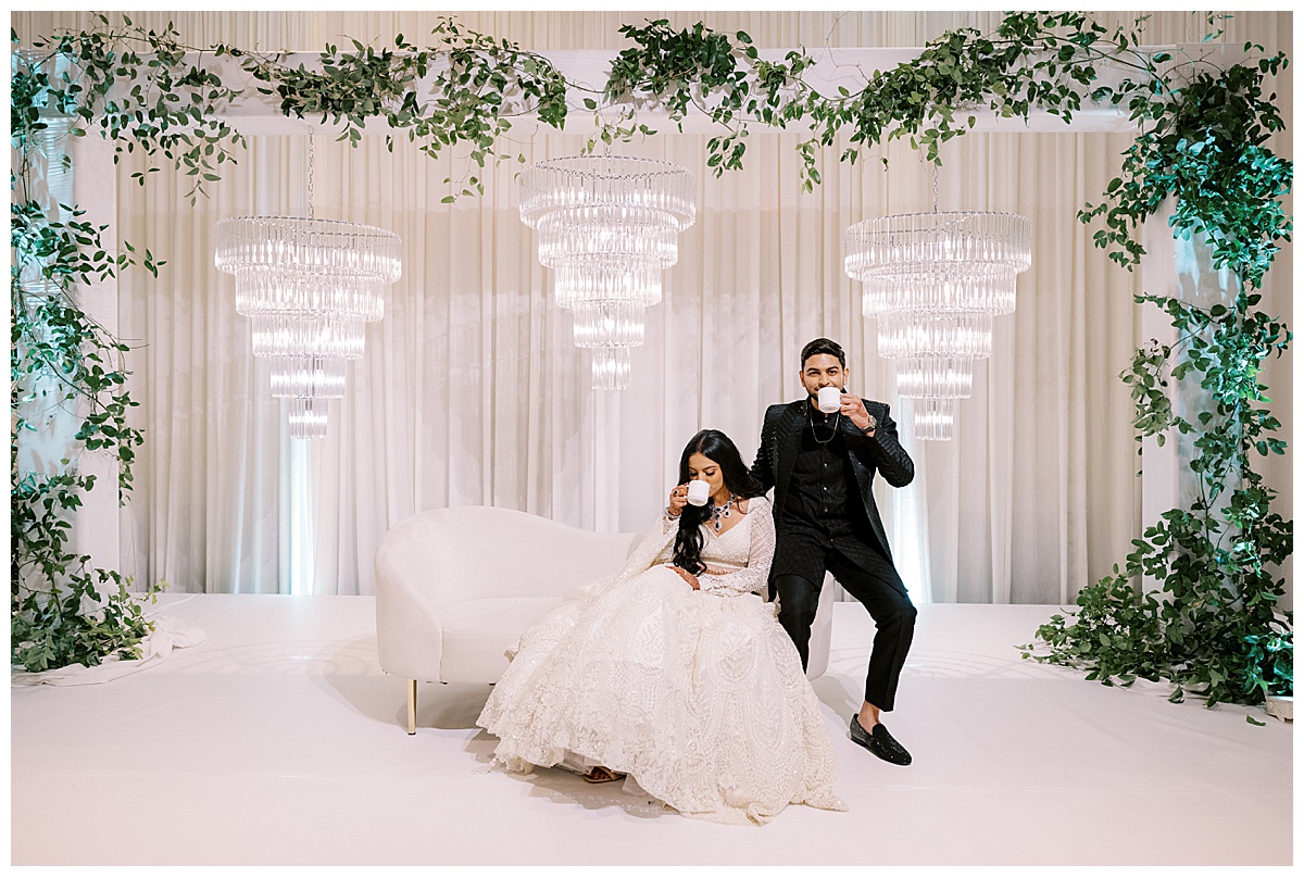 Bride and groom sipping tea on the stage at their Hyatt SFO Indian wedding reception