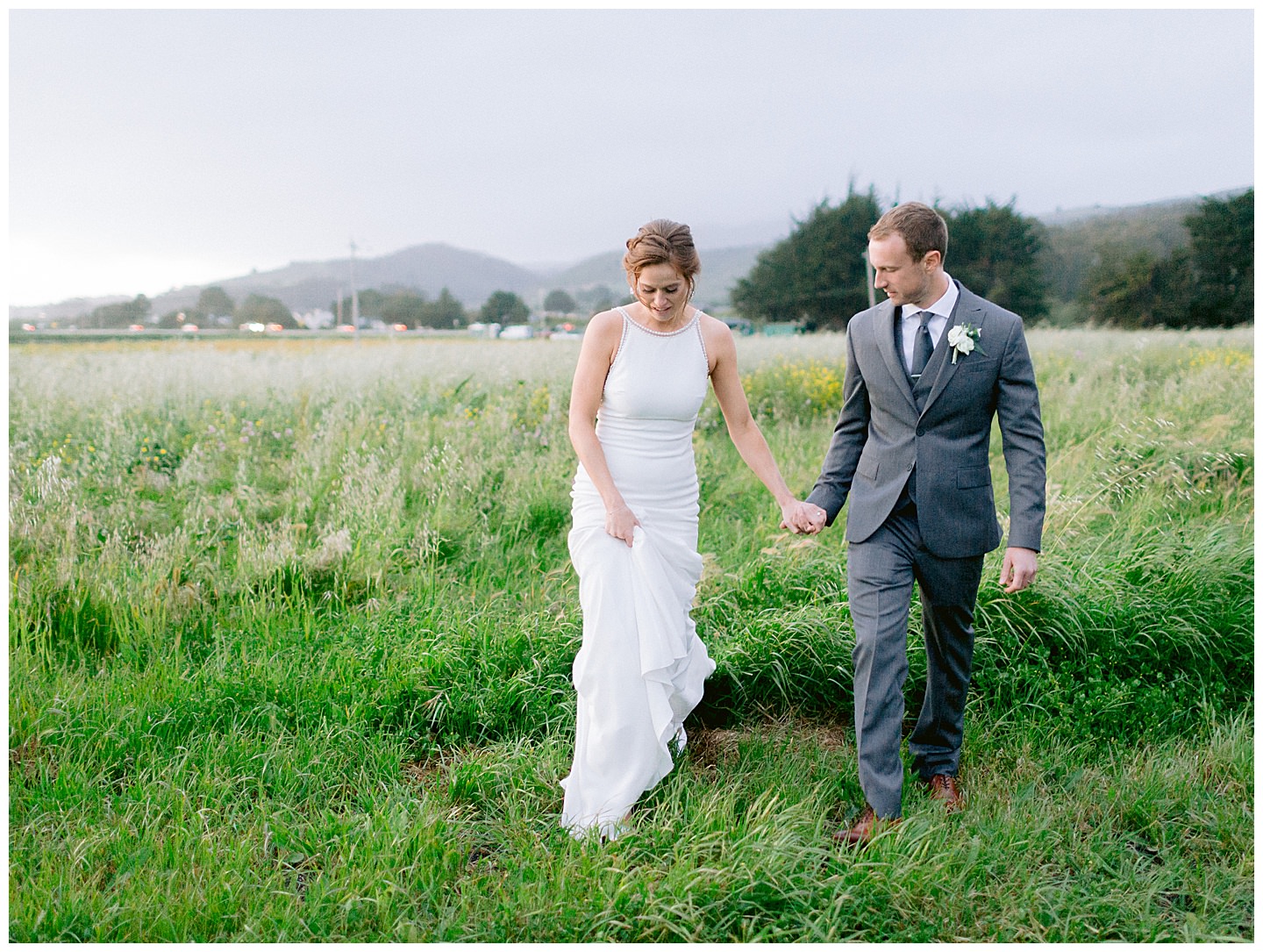 couple walking through a field in half moon bay
