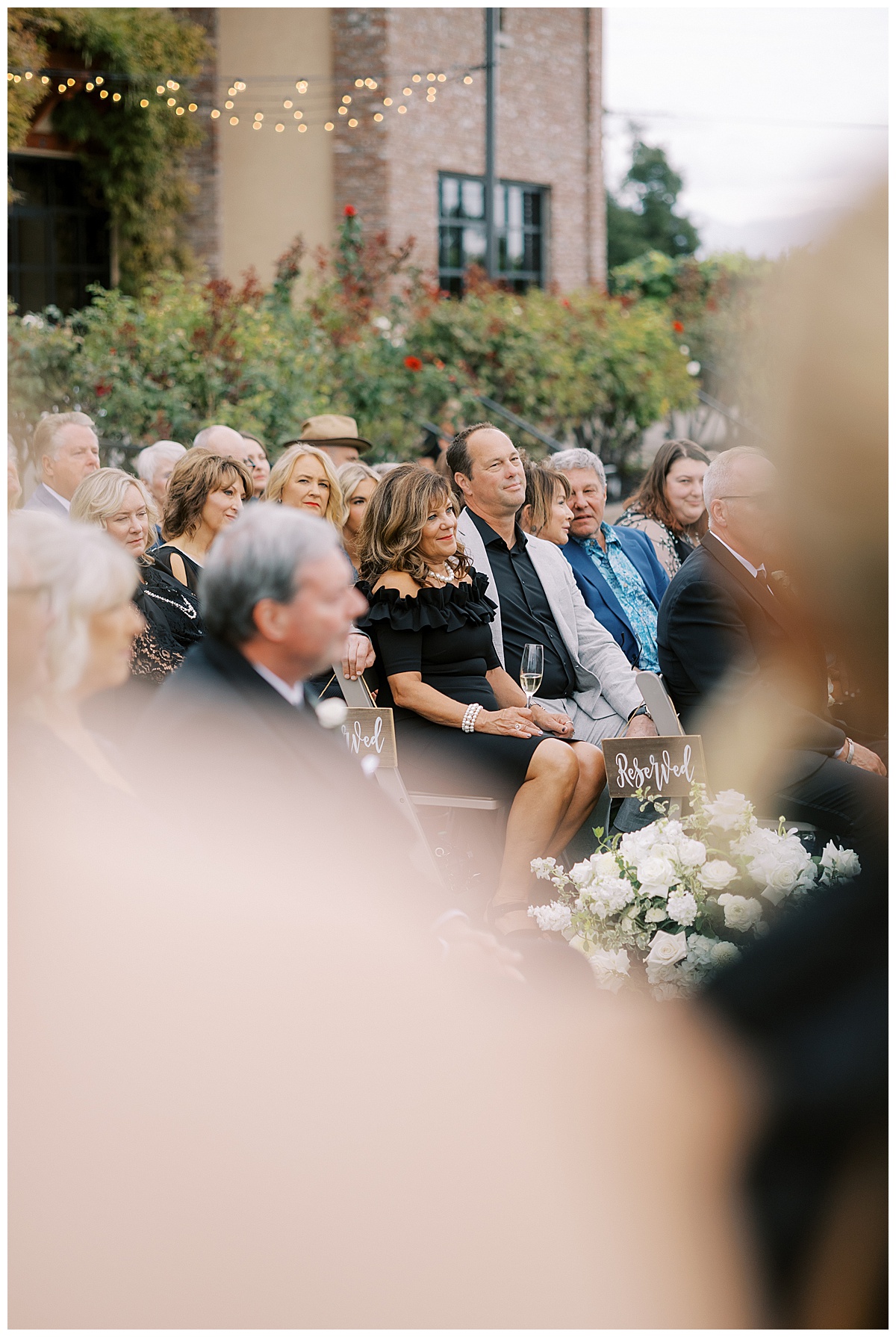 mother of the bride smiling through crowd during wedding ceremony