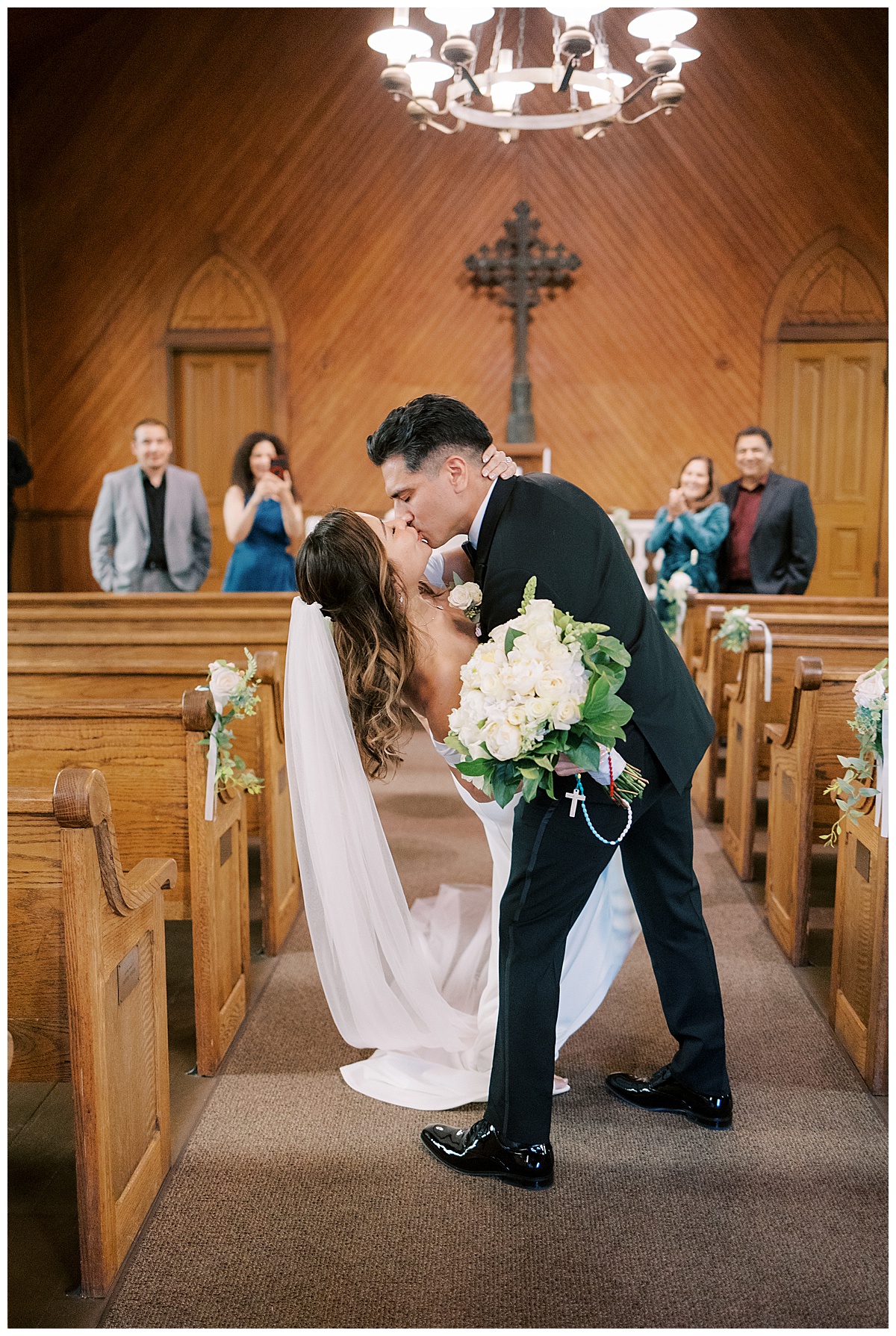 newlywed couple kissing in the aisle while groom dips bride after old st. Hilary's elopement 