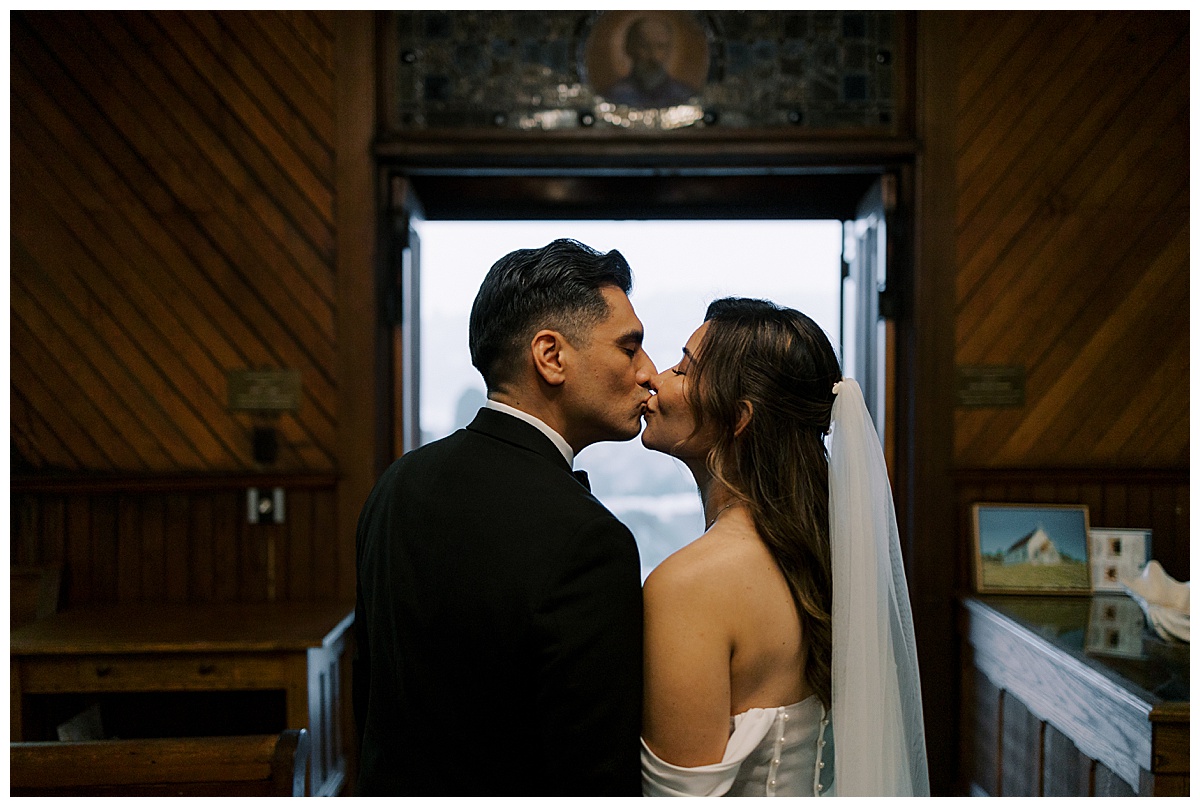 newlywed couple kissing in the doorway of old st. Hilary's church after elopement ceremony