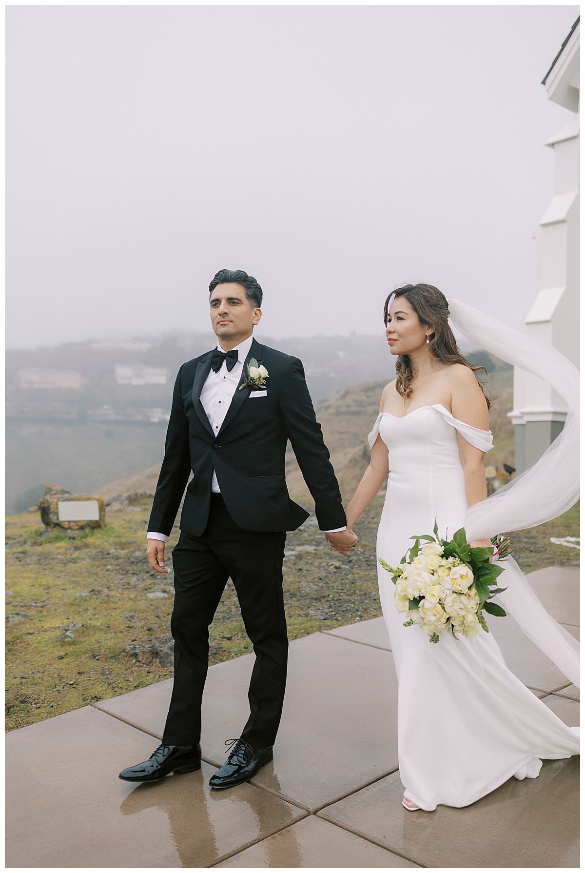 couple holding hands with a foggy romantic background at st. Hilary's church