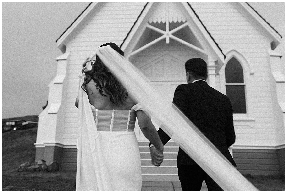 black and white photo of couple running away from camera