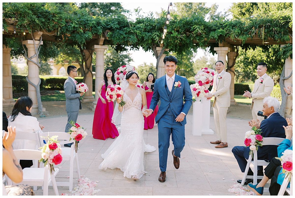 newly married asian couple walking back up the aisle after their ceremony at the club at ruby hill
