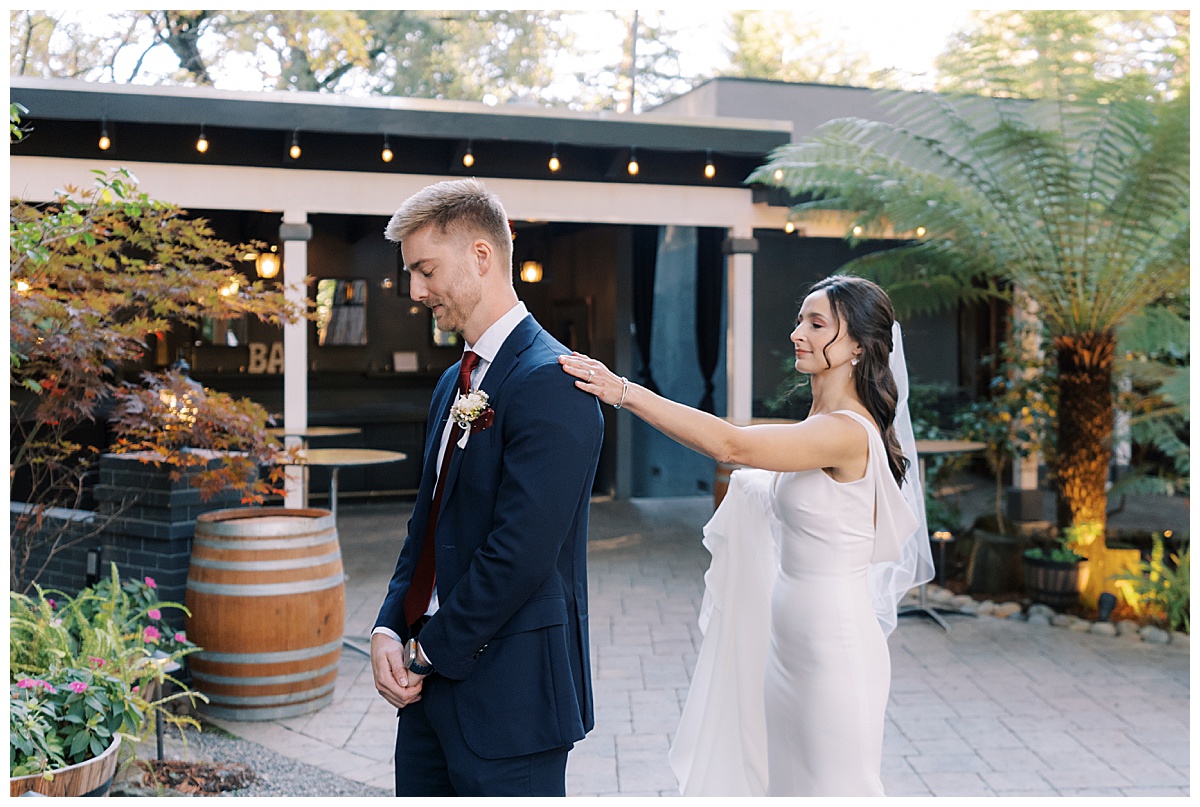 bride taps grooms shoulder during first look at deer park villa