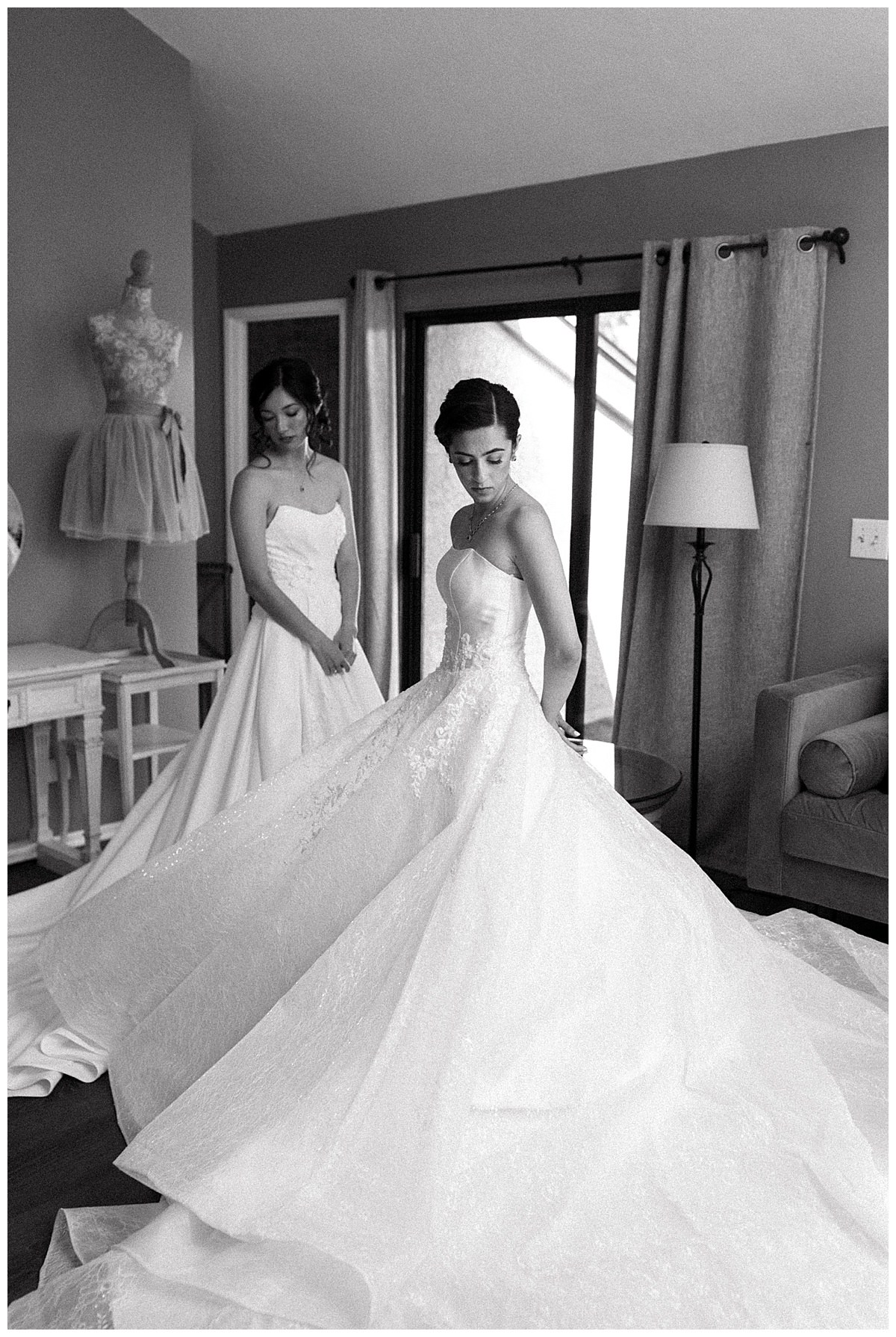 black and white photo of two brides wearing wedding ball gowns in getting ready space at maravilla gardens in camarillo 
