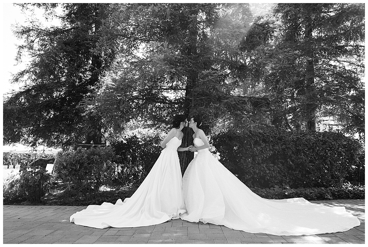 two brides kissing in wedding gowns at maravilla gardens wedding