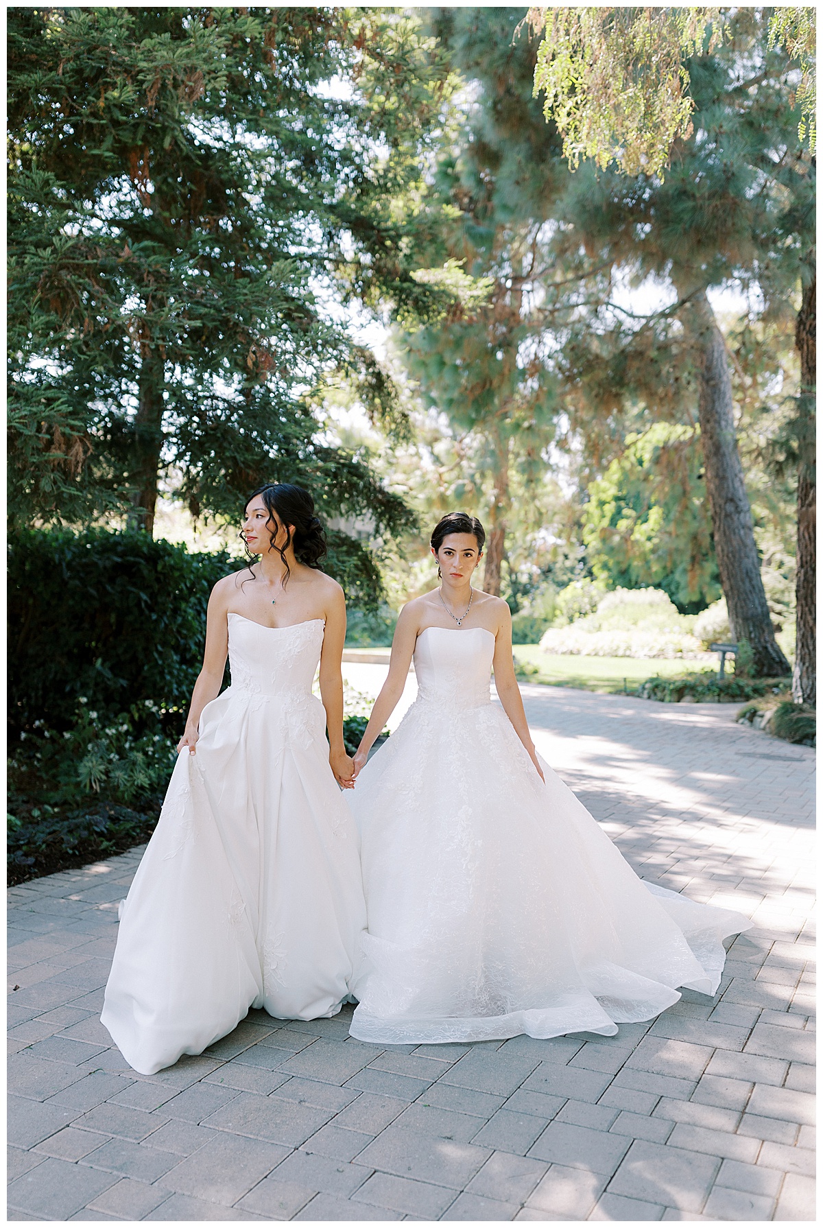 lesbian couple holding hands and walking at maravilla gardens under the trees