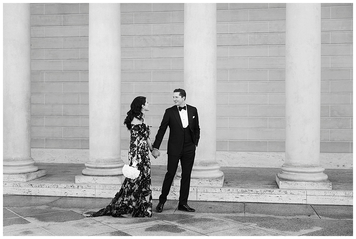 black and white photo of elegantly dressed bride and groom walking at legion of honor in San Francisco 