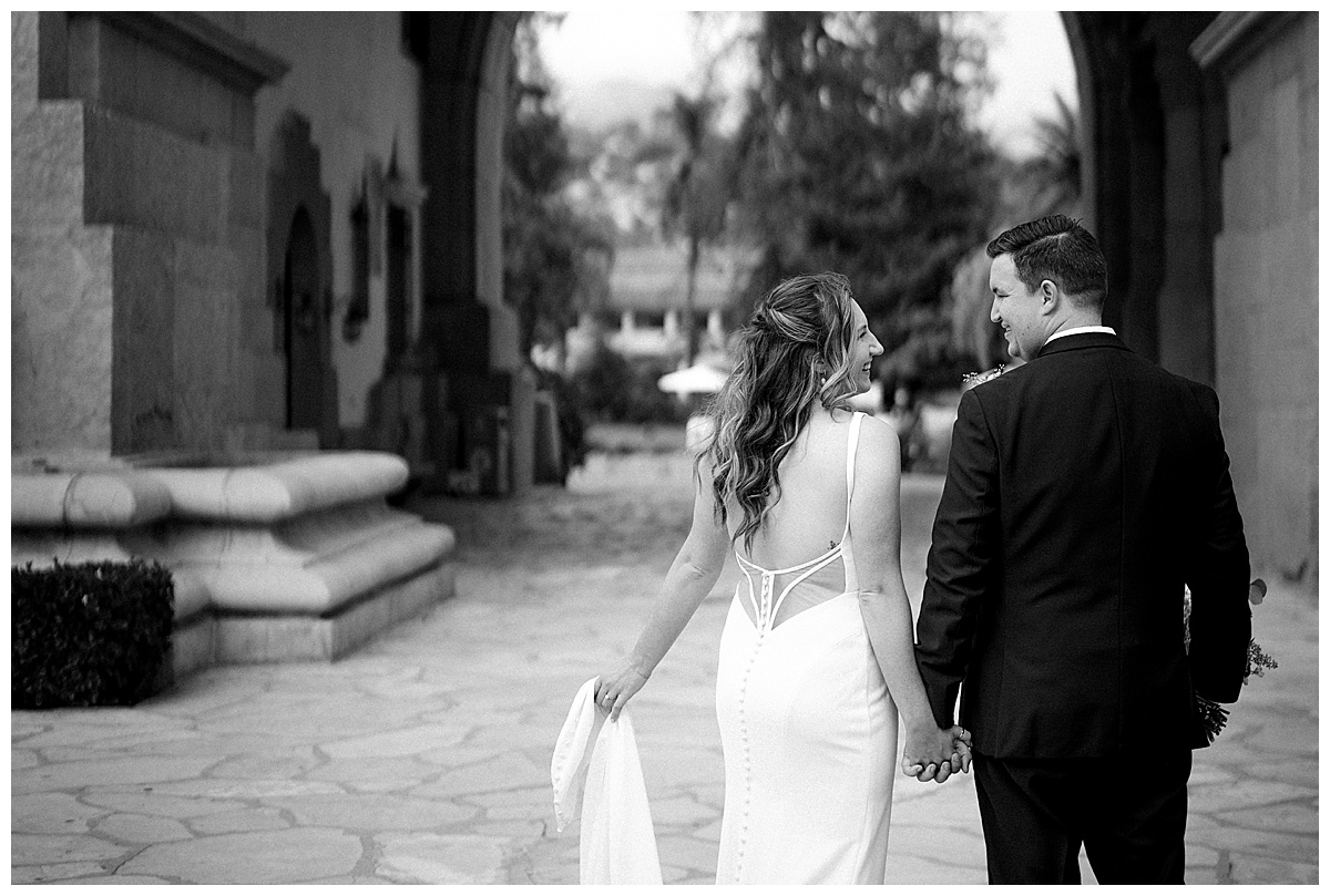 black and white photo of bride and groom walking through downtown Santa Barbara 