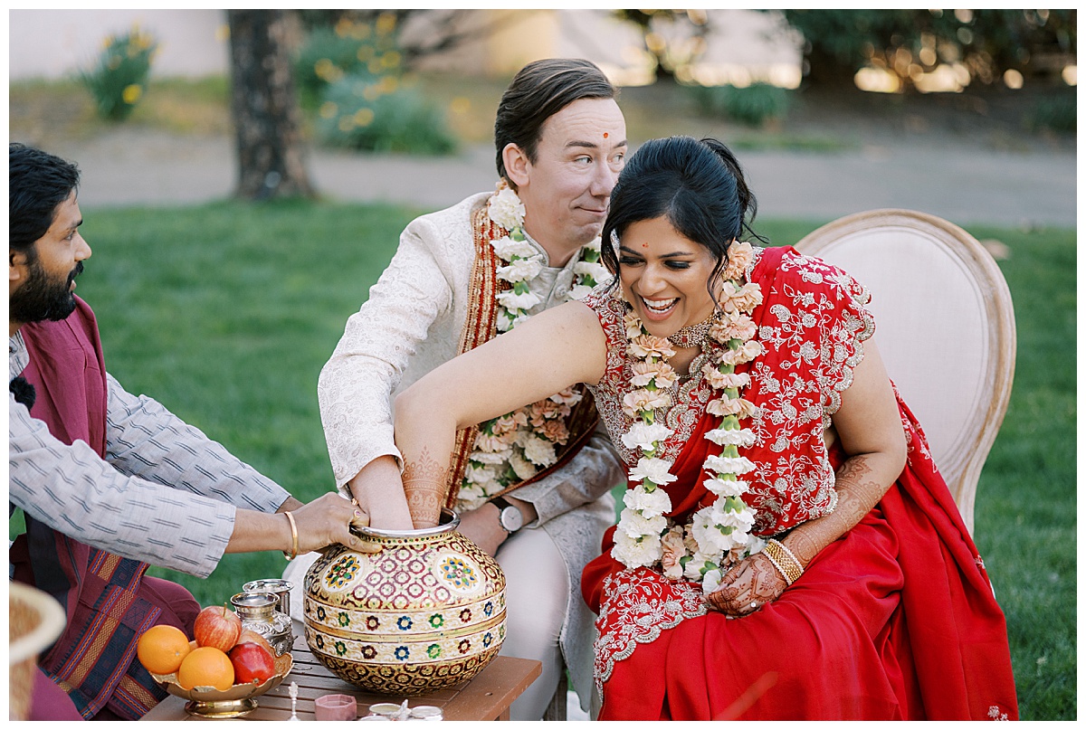 Couple playing a game during Indian wedding ceremony