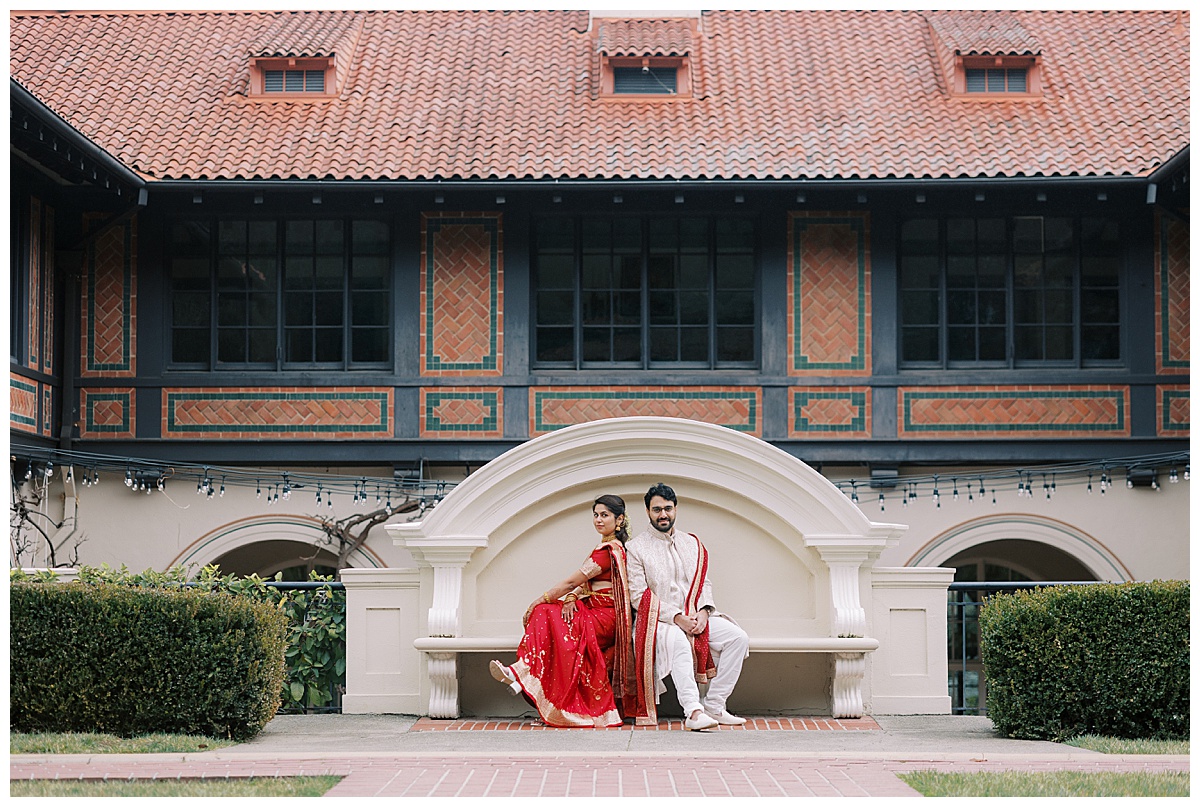 Indian couple sitting in front of Montalvo arts center during engagement session