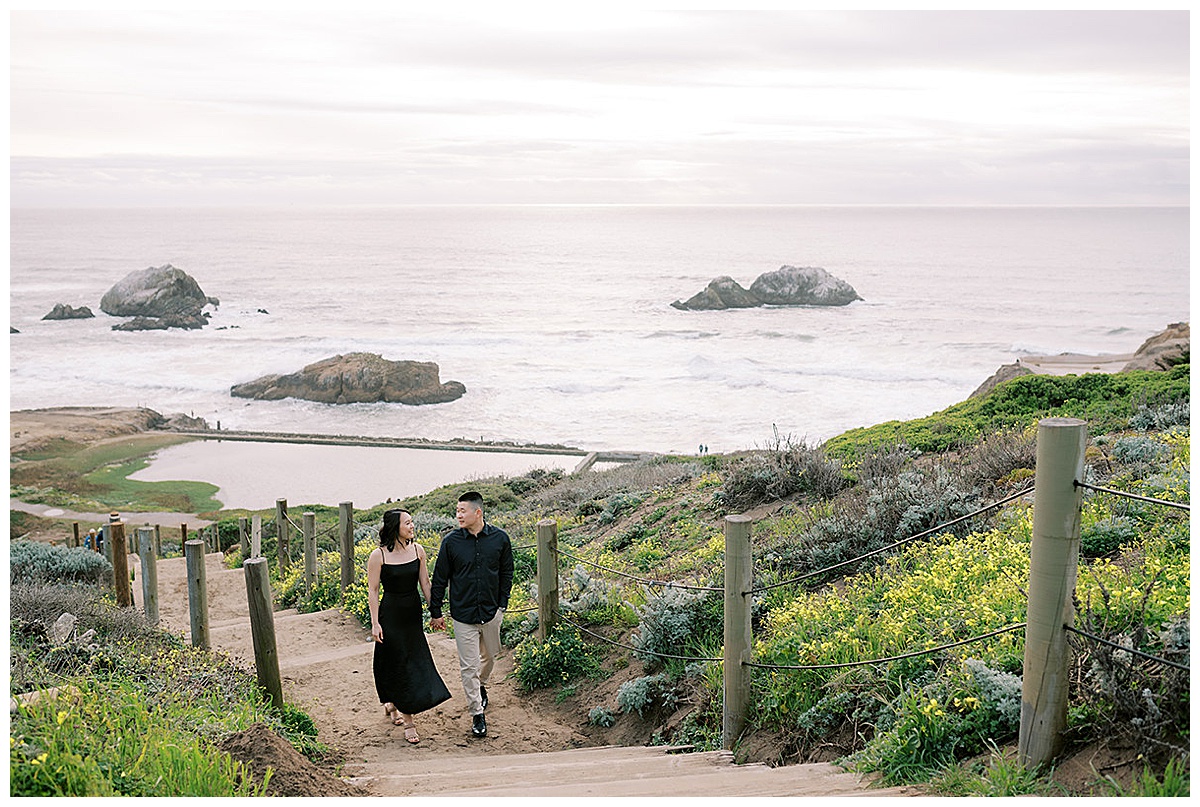 couple walking up stairs at sutro baths during engagement session