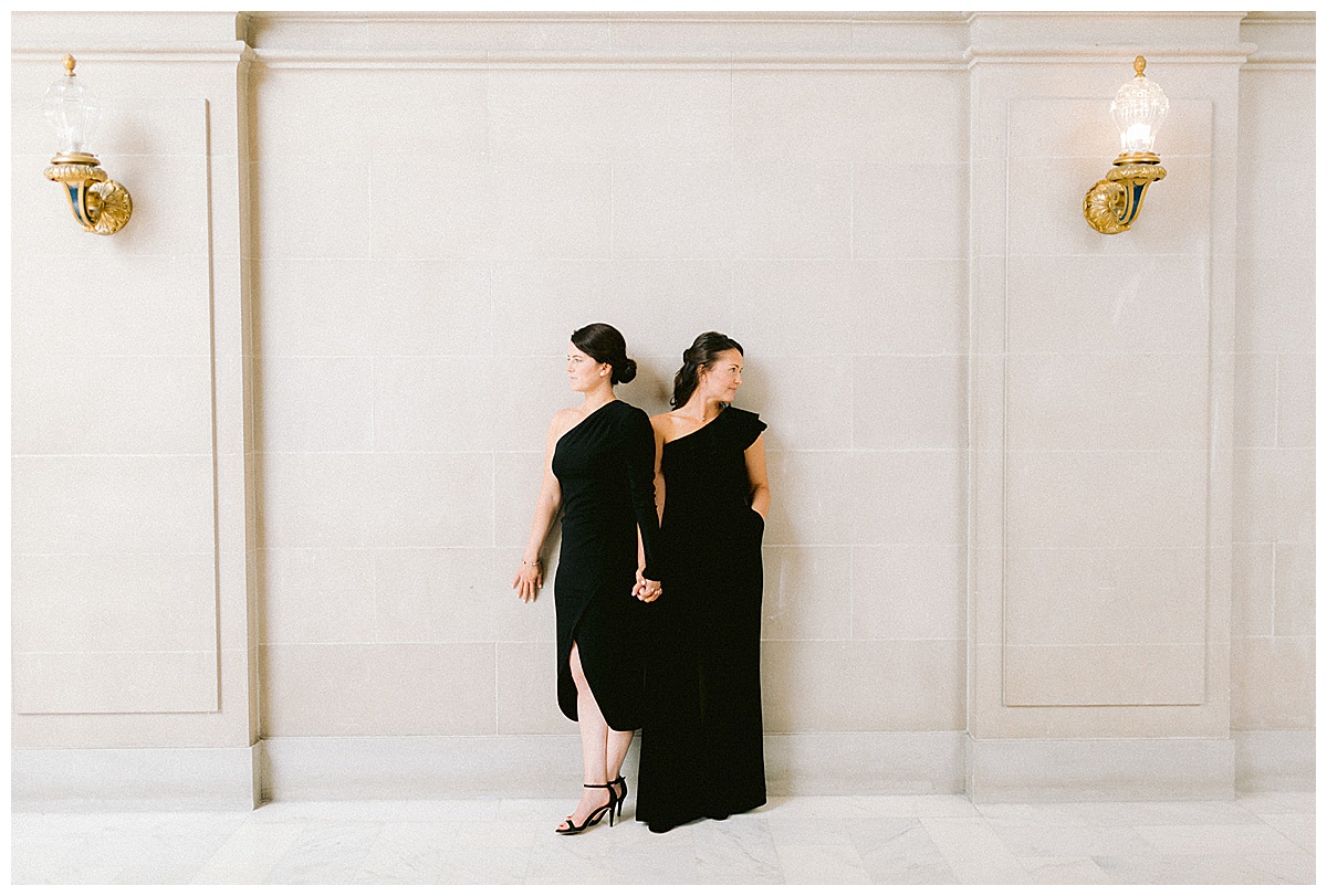 lesbian couple posing in city hall for engagement photos