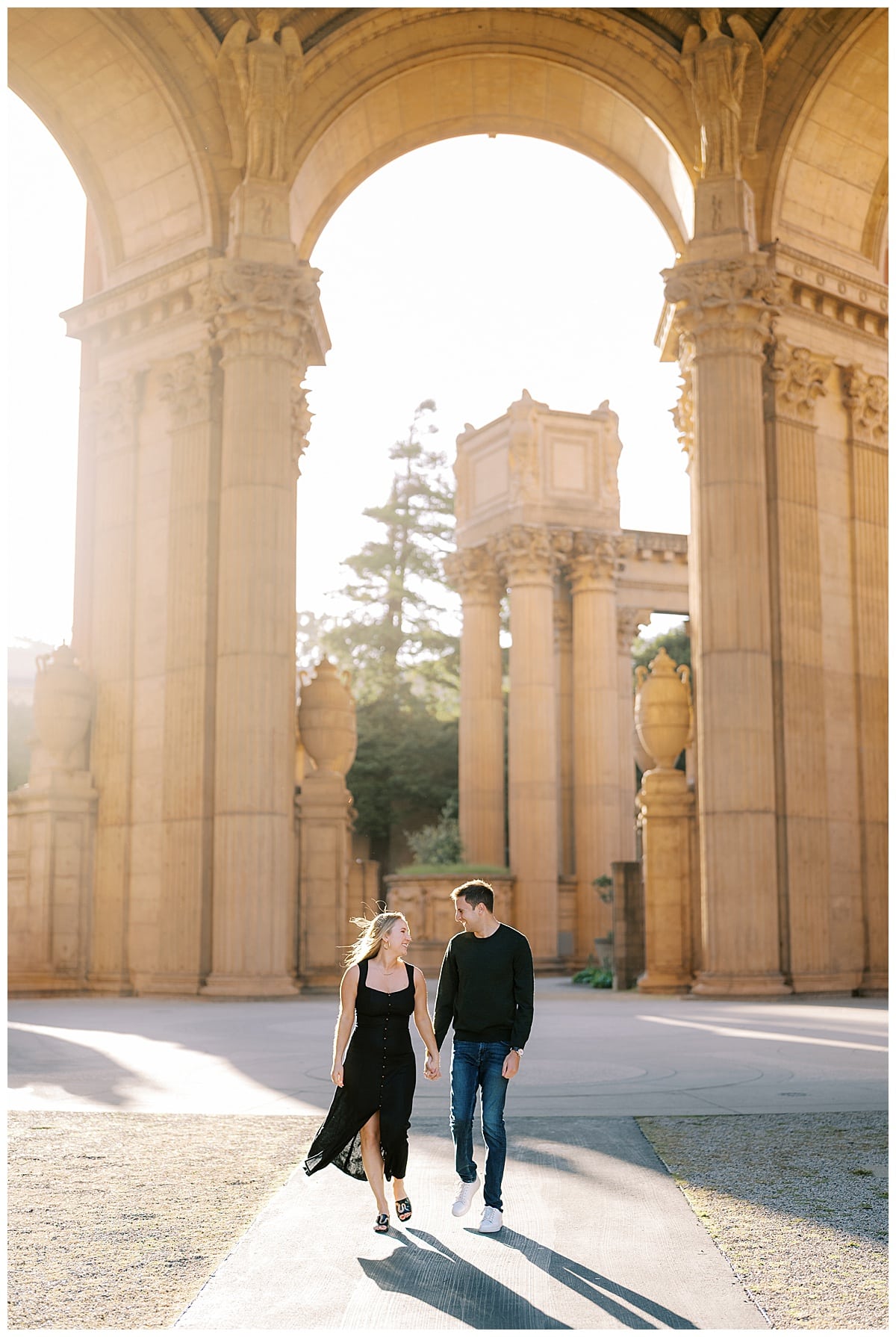 couple walking through palace of fine arts at sunset
