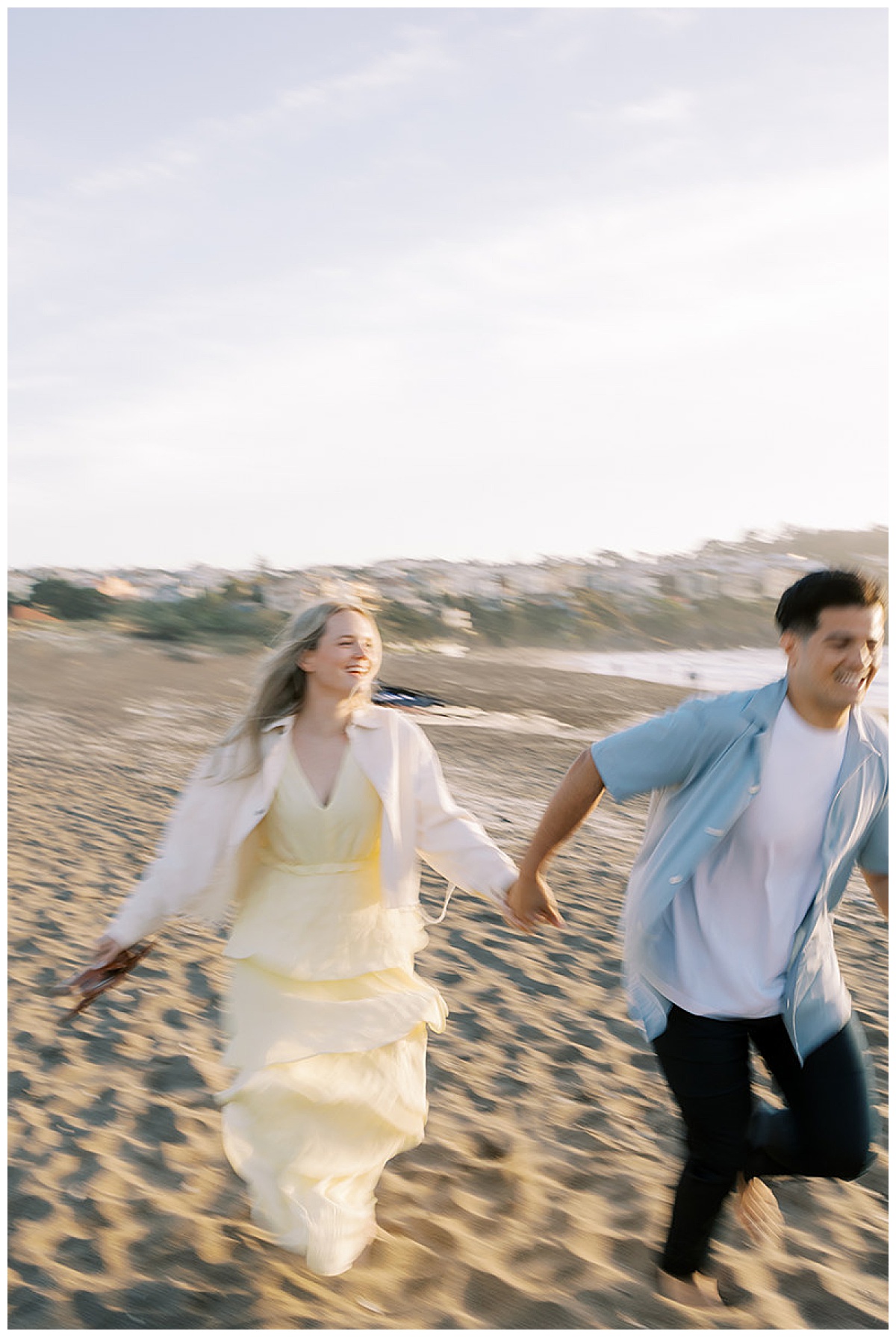 semi blurry photo of couple running on beach at baker beach
