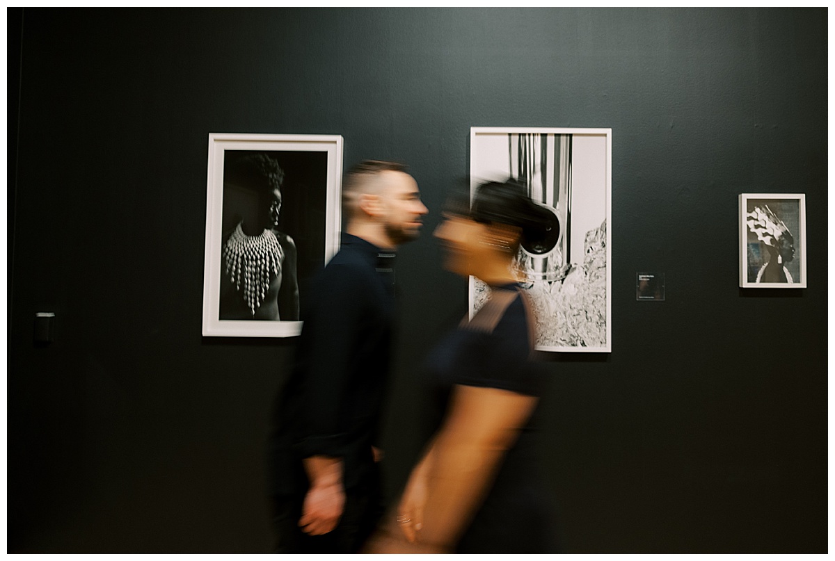 blurry couple walking past art at the sf moms